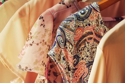 collection of women's clothes hanging on rack for sale photo