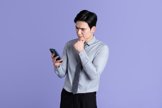 Portrait of Asian male businessman posing on purple background photo