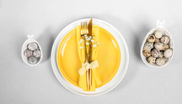 Elegant Easter table serving in white yellow colors. Beautiful tableware, golden cutlery, quail eggs photo