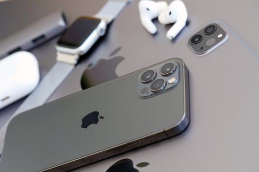 KYIV, UKRAINE - 4 MAY, 2023 Apple brand devices iphone, ipad and airpods with apple watch lies on macbook body photo