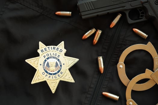 KYIV, UKRAINE - MARCH 9, 2024 US Retired Police Officer badge on black jacket uniform with gun, bullets and handcuffs photo