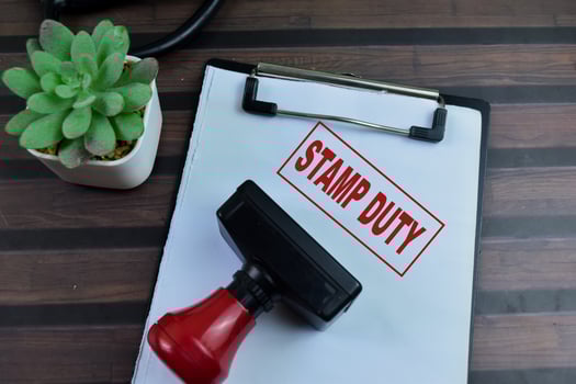 Red Handle Rubber Stamper and Stamp Duty text above paperwork isolated on wooden background photo