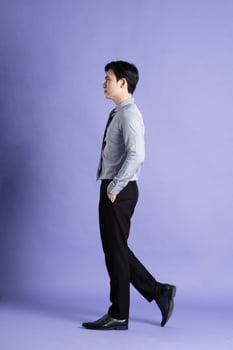 Portrait of Asian male businessman standing and posing on purple background photo