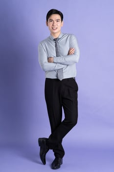 Portrait of Asian male businessman standing and posing on purple background photo