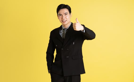 Portrait of Asian male businessman. wearing a suit and posing on a yellow background photo