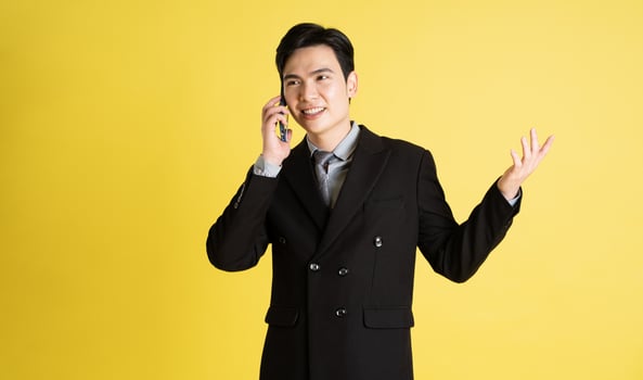 Portrait of Asian male businessman. wearing a suit and posing on a yellow background photo