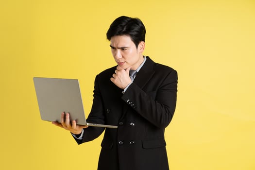Portrait of Asian male businessman. wearing a suit and posing on a yellow background photo