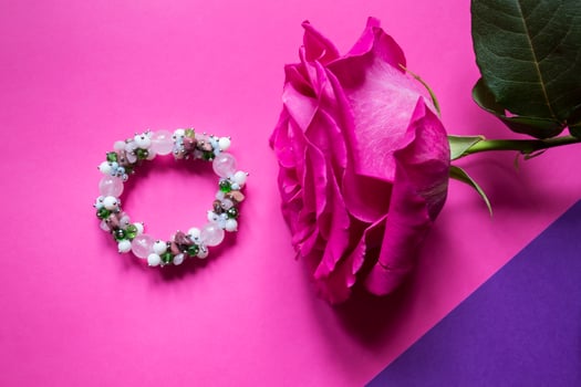 The hand bracelet with decor on pink background. photo