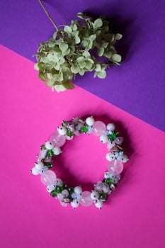 The hand bracelet with decor on pink background. photo