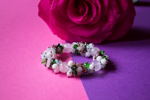 The hand bracelet with decor on pink background. photo