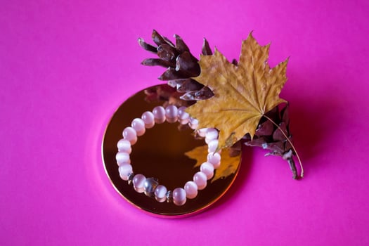 The hand bracelet with decor on pink background. photo