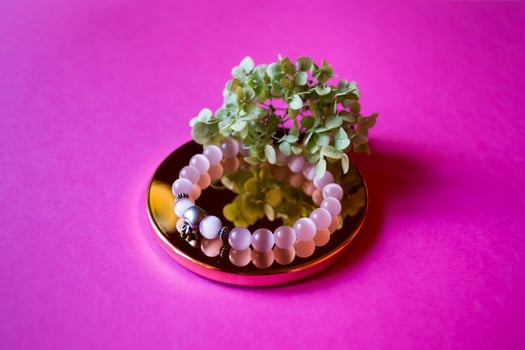 The hand bracelet with decor on pink background. photo
