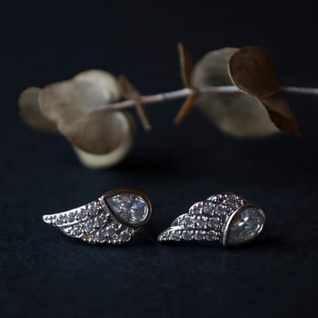 Silver earrings on a black background with decor photo