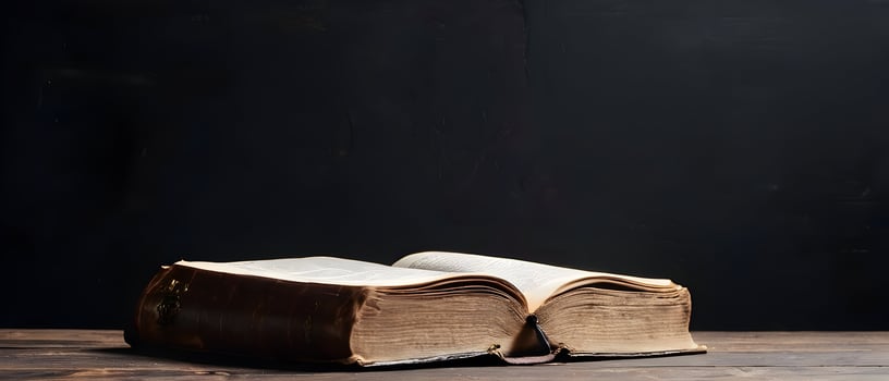 Old holy bible on old rustic vintage wooden table and black wall. Church faith Christian background banner panorama photo
