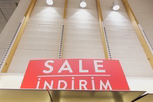 Large red Sale text letters on a glass wall obstruct a view inside the popular fashion store photo