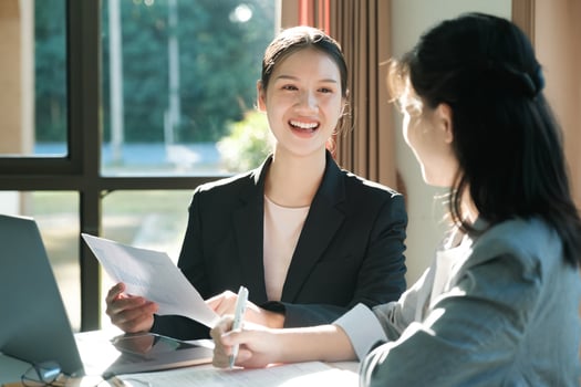 Two women in business suits are talking to each other photo