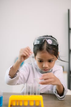 Asian child girl learning science chemistry with test tube making experiment at school laboratory. education, science, chemistry, and children's concepts. Early development of children. photo