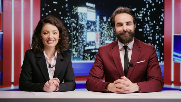 Reporters team hosting night show late to discuss about latest celebrity scandals in newsroom, covering all important topics on worldwide television network. Broadcasters hosts presenting breaking news. photo