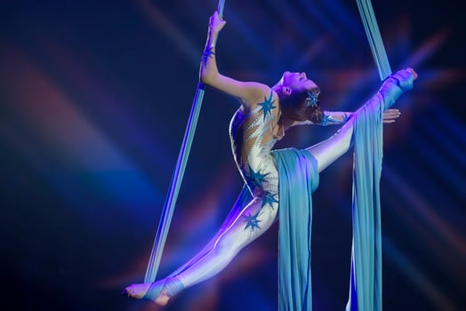 Performance by a circus acrobat artist. Girls perform aerial acrobatic elements on fabric. photo