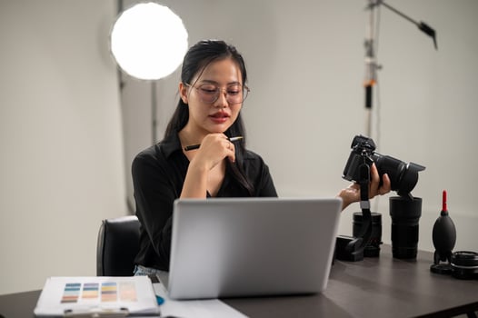 A professional Asian female photographer is focusing on checking images on her laptop. photo