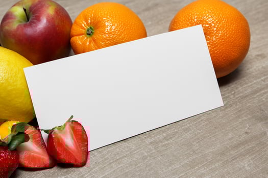 Card and White Paper Mockup Harmonized with Fresh Fruit, Crafting a Visual Symphony of Artful Design and Culinary Delight, Where Wholesome Ingredients Merge in a Feast of Vibrant Imagery photo