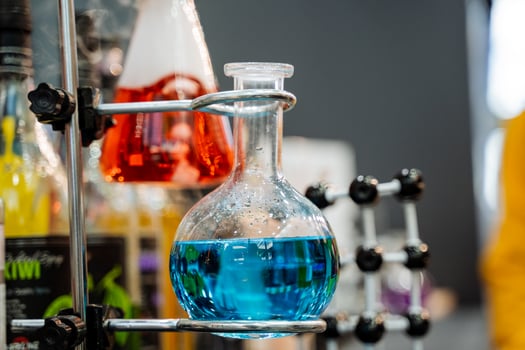 Glass flask with a blue composition in a chemical laboratory, the study of the interaction of various petrochemical elements, science at the university. photo