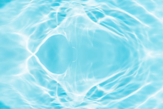 Bluewater waves on the surface ripples blurred. Defocus blurred transparent blue colored clear calm water surface texture with splash and bubbles. Water waves with shining pattern texture background. photo