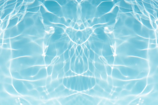 Bluewater waves on the surface ripples blurred. Defocus blurred transparent blue colored clear calm water surface texture with splash and bubbles. Water waves with shining pattern texture background. photo