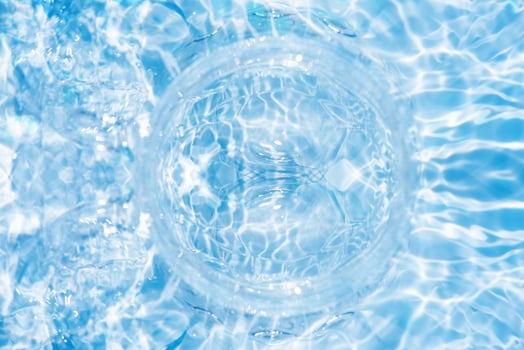 Bluewater waves on the surface ripples blurred. Defocus blurred transparent blue colored clear calm water surface texture with splash and bubbles. Water waves with shining pattern texture background. photo