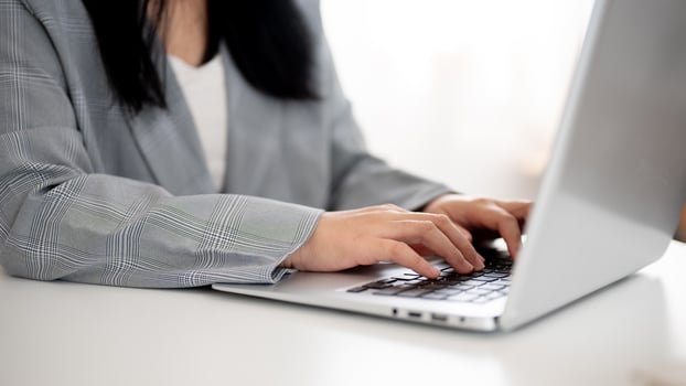 A cropped image of a businesswoman working or browsing on the laptop, working in a modern office. photo