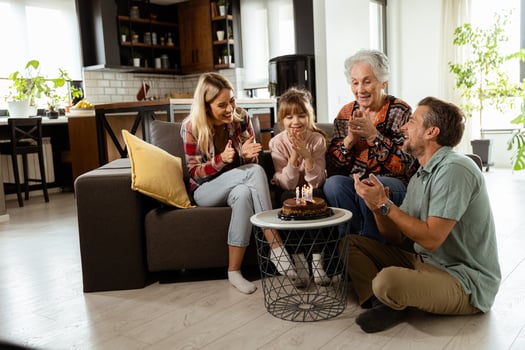 Joyous Family Celebrating Grandmothers Birthday With Cake in a Cozy Living Room photo