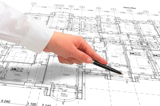 Woman architect in white shirt showing some details on the floor plan layout with a pen, close up of a hand photo