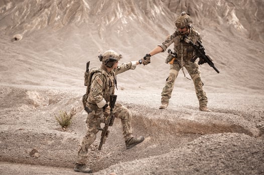 Soldiers in camouflage uniforms aiming with their riflesready to fire during military operation in the desert soldiers training  in a military operation photo