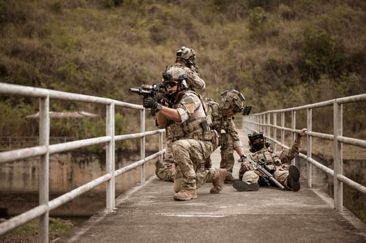 Soldiers  in camouflage uniforms aiming with their riflesready to fire during Military Operation in the forest  soldiers training  in a military operation photo
