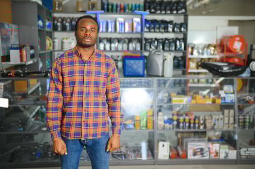 Portrait of a handsome african salesman in an auto parts store. The concept of car repair photo
