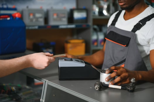 Close up. The buyer pays for the purchase of auto parts through a POS terminal photo