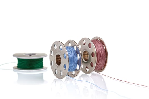 spools of blue and pink thread on a white background photo
