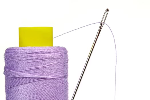 Macro skein of thread purple colors with a needle on a white background photo