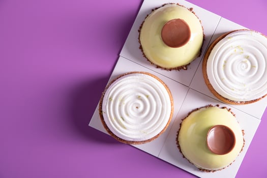 a variety of original cakes top view boxes on a purple background, culinary photo