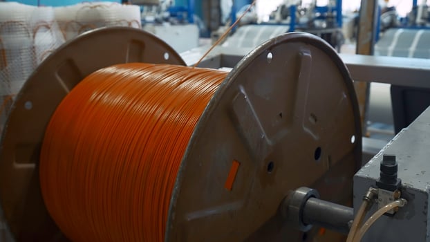 Spinning reel with rubber wire. Creative. Unwinding coil with rubber wire for insulation. Industrial production with rubber wires photo