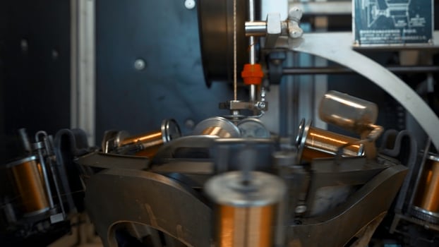 Automated machine with rotating coils and wire. Creative. Coils rotate on stack with winding wire. Industrial machine rotates and winds copper wire photo