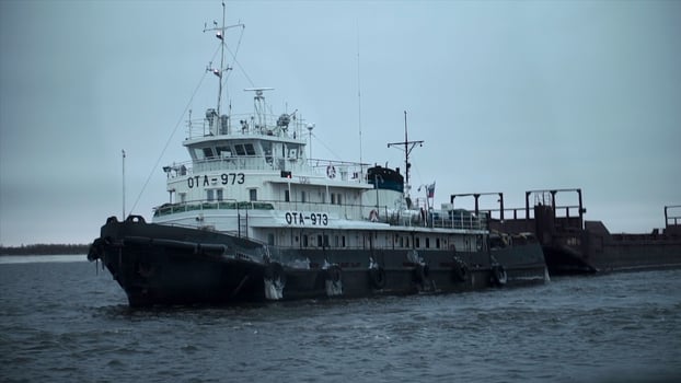 Beautiful sea vessel at pier in winter. Clip. Naval vessel with numbers and flag is preparing to sail at pier. Marine vessel at berth of north coast in winter photo