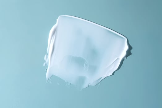 Stroke of white cream on a blue background. photo