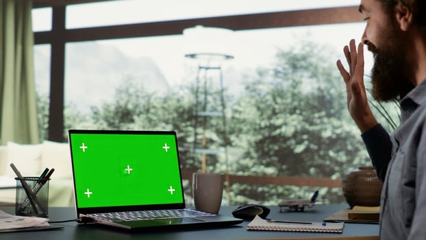 Rich businessman looks at greenscreen on pc, being cozy in his luxurious villa in the woods. Shareholder of multinational company logs onto laptop with isolated chromakey, billionaire lifestyle. photo