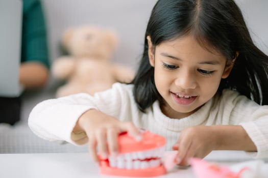 A young girl is playing with a toy toothbrush photo