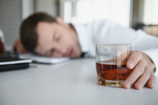 Businessman drinking from stress at workplace photo