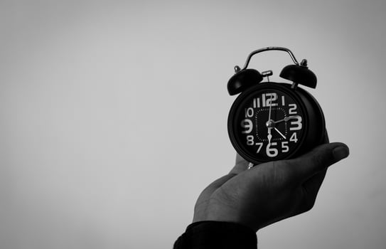 Time management concept. Man hands holding Black retro alarm clock. Time to wake up for the morning routine photo