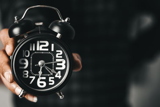 Time management concept. Man hands holding Black retro alarm clock. Time to wake up for the morning routine photo