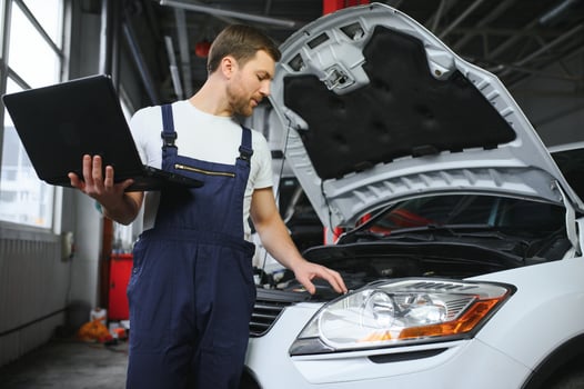 Auto service, repair, maintenance concept. mechanic checks the car, making diagnostics with laptop at the service station. Service maintenance of industrial to engine repair. photo