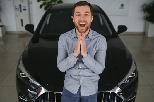 Visiting car dealership. Handsome bearded man is stroking his new car and smiling photo